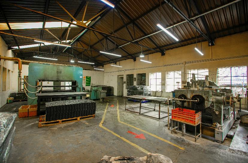Stacked rubber mats beside production equipment at the Highrange factory